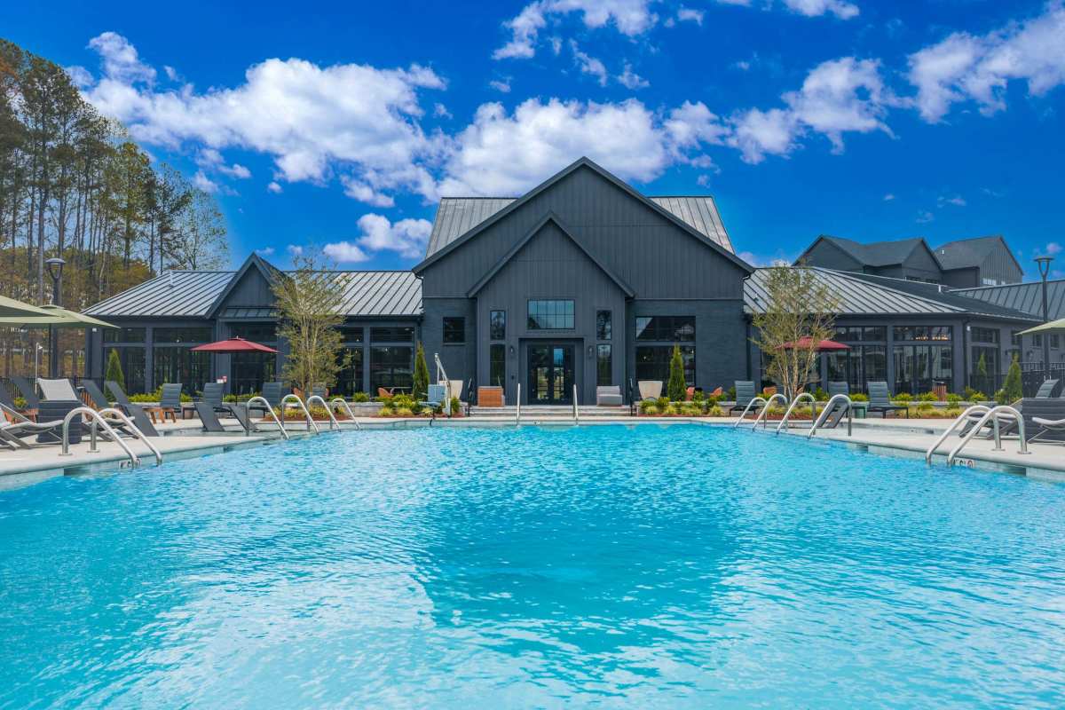 Infinity-edge pool and dark barn-style clubhouse